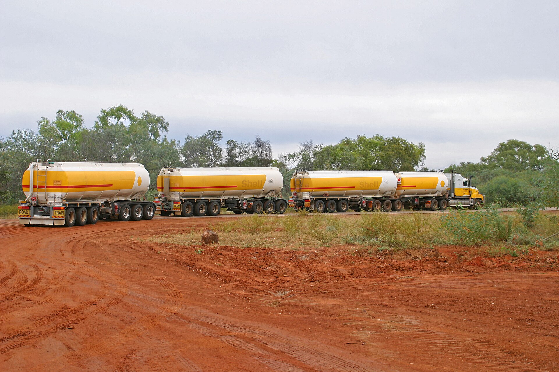 A multi-trailer road train on a red dirt road in Australia