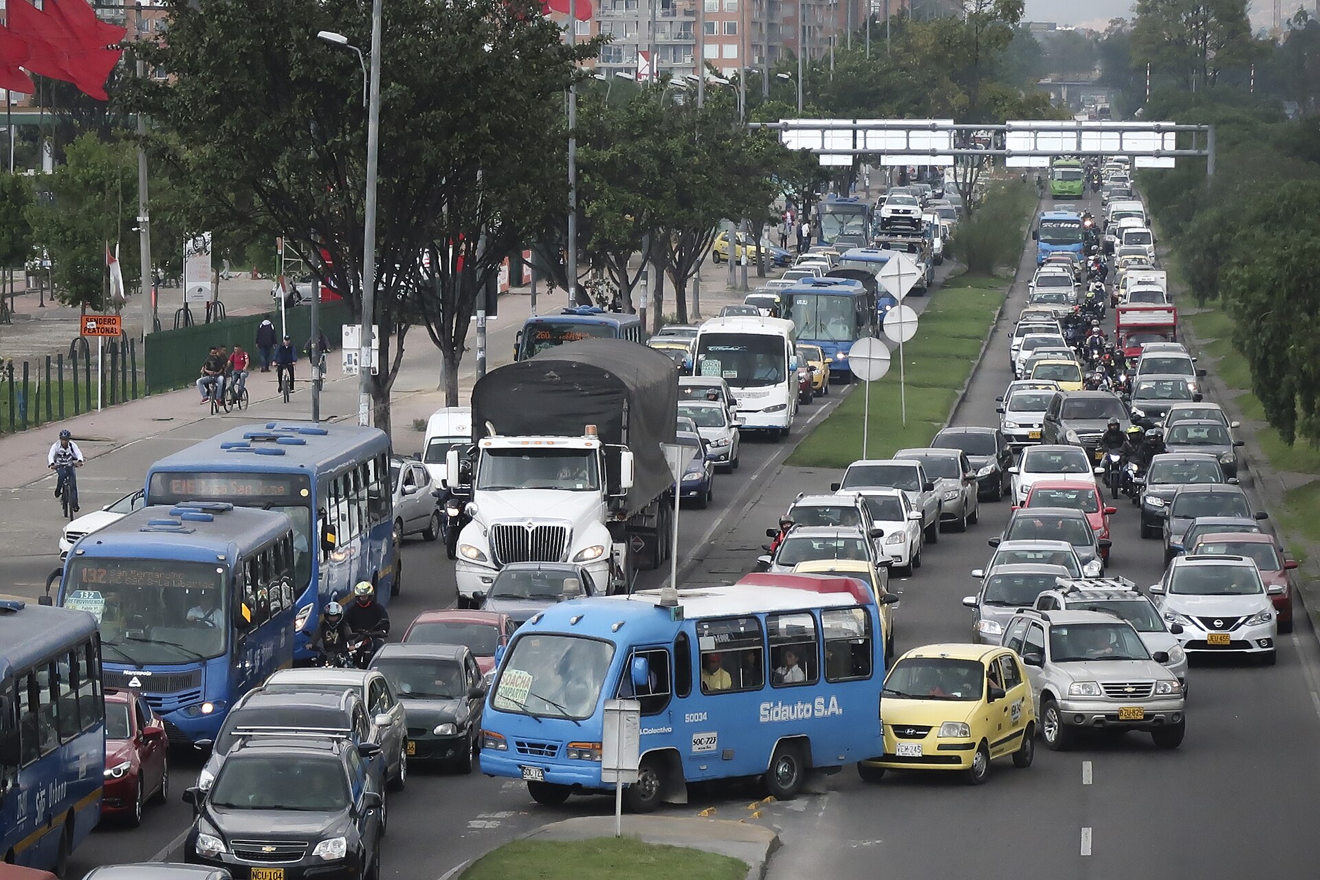 Heavy traffic with buses, taxis and motorcycles on a Bogotá avenue