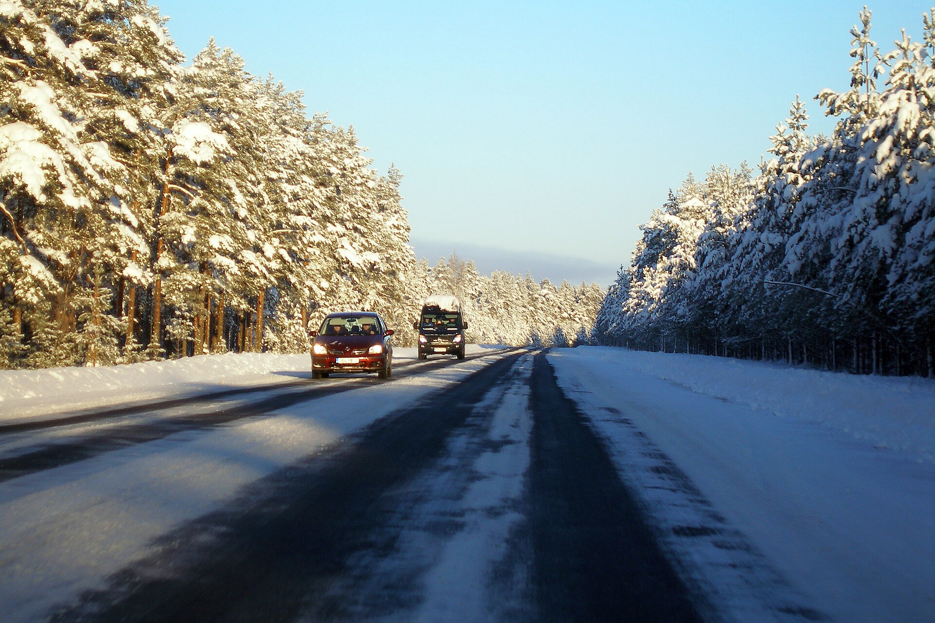 Snow-covered two-lane road through the Lahemaa area with cars approaching