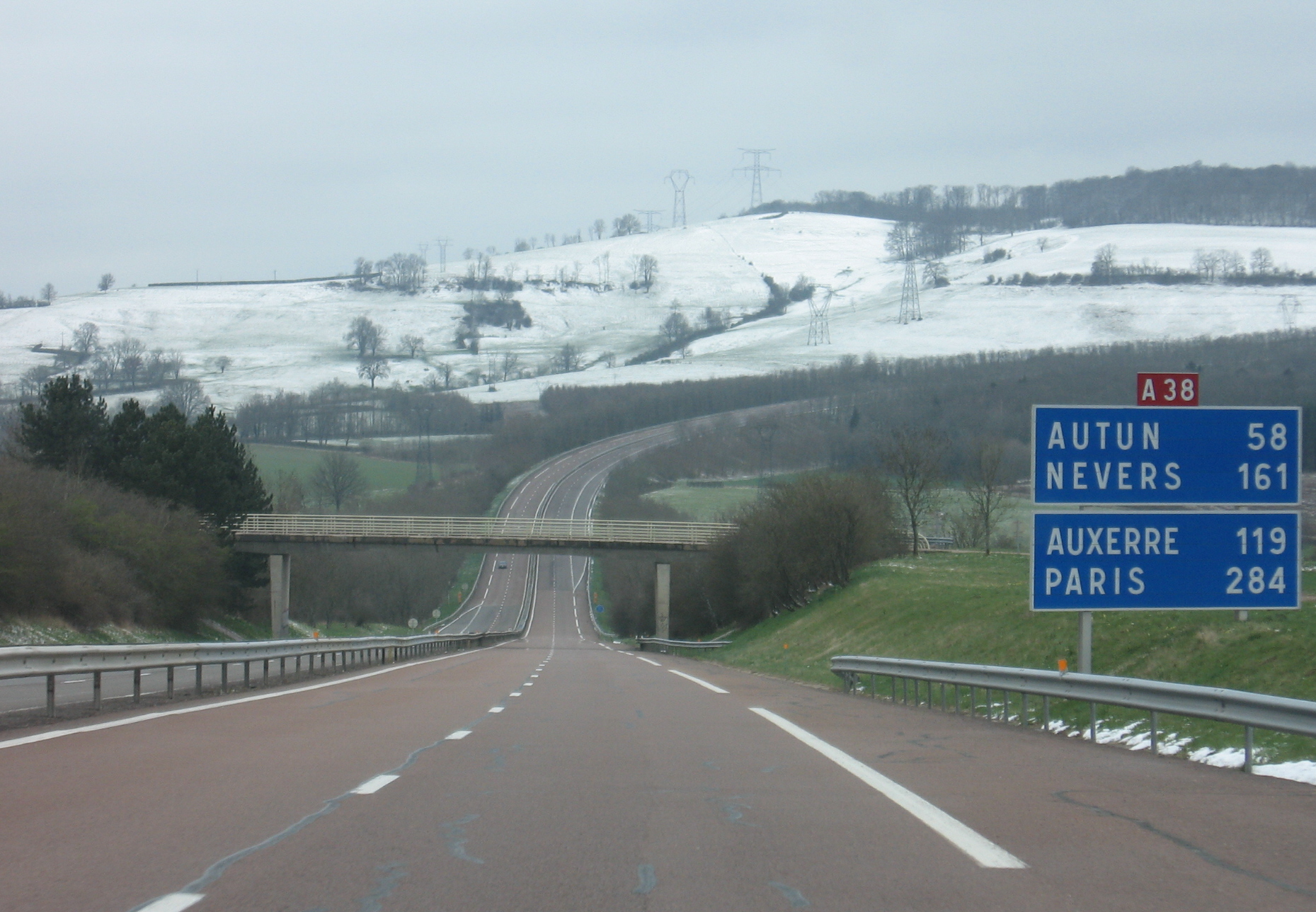 A38 autoroute crossing the winter countryside near France's Autun and Nevers direction signs