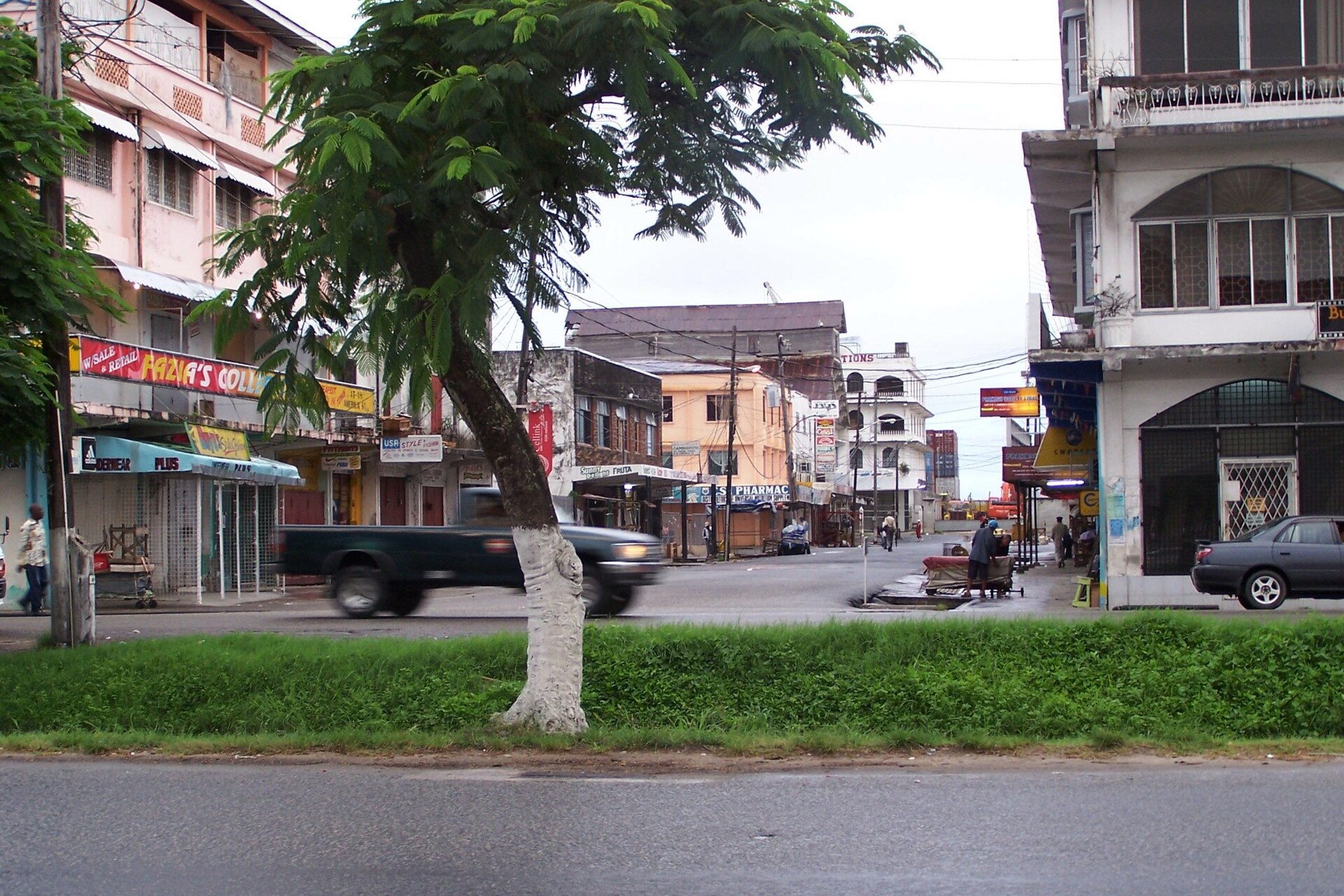 Typical Georgetown street in Guyana with low-rise buildings and roadside traffic