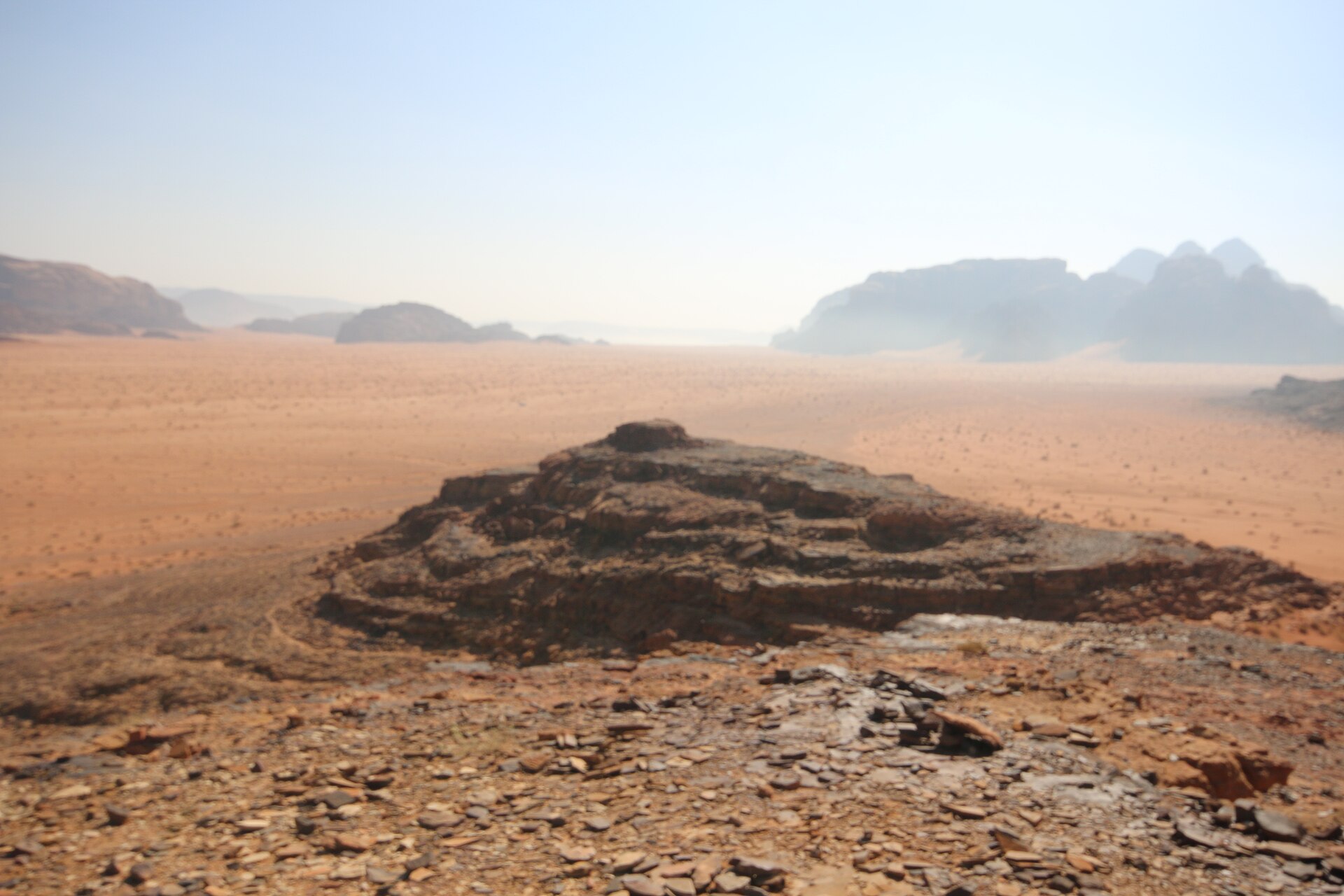 Rocky desert landscape in Wadi Rum, Jordan, under a pale morning sky