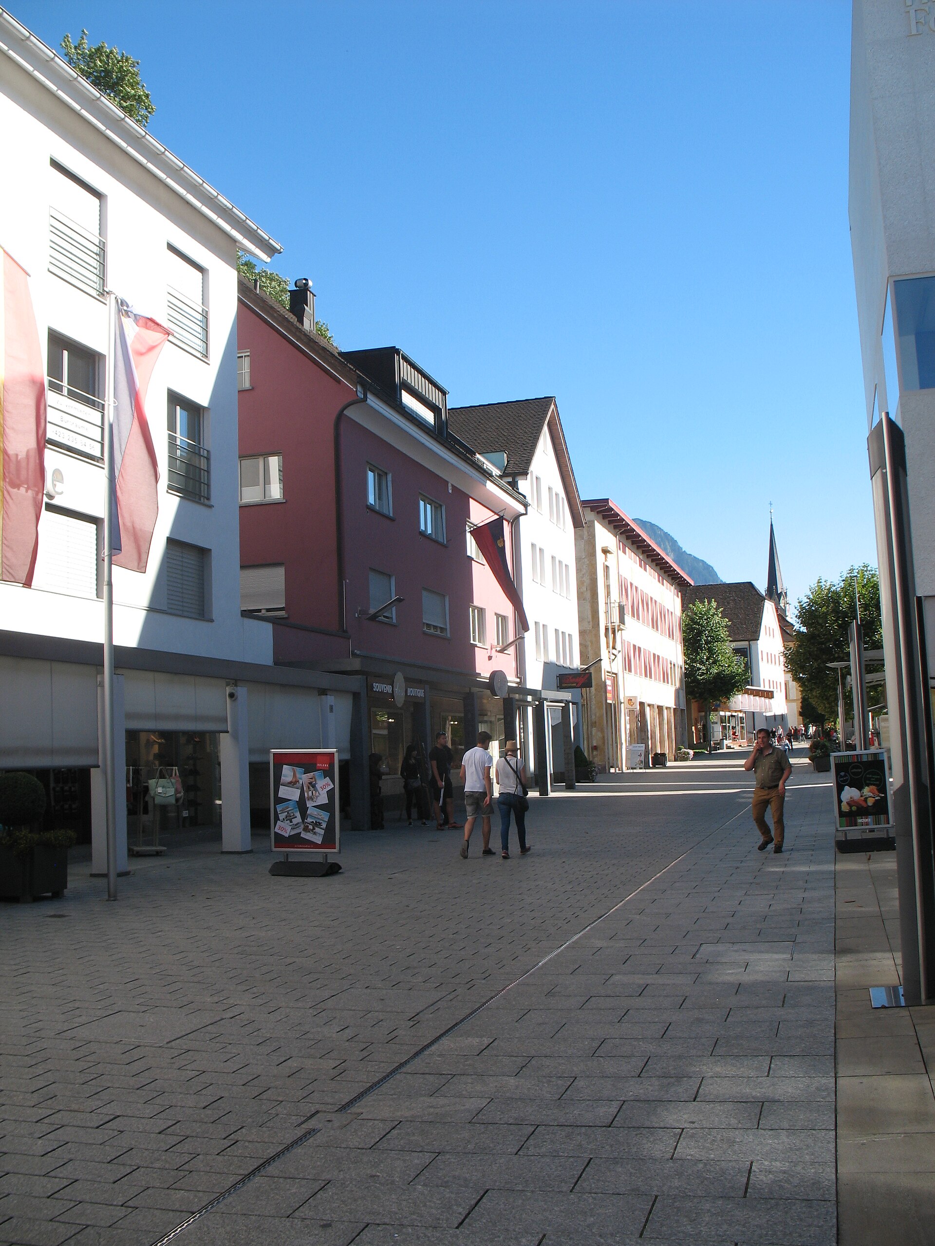 A street in Vaduz with the Liechtenstein Alps behind the town