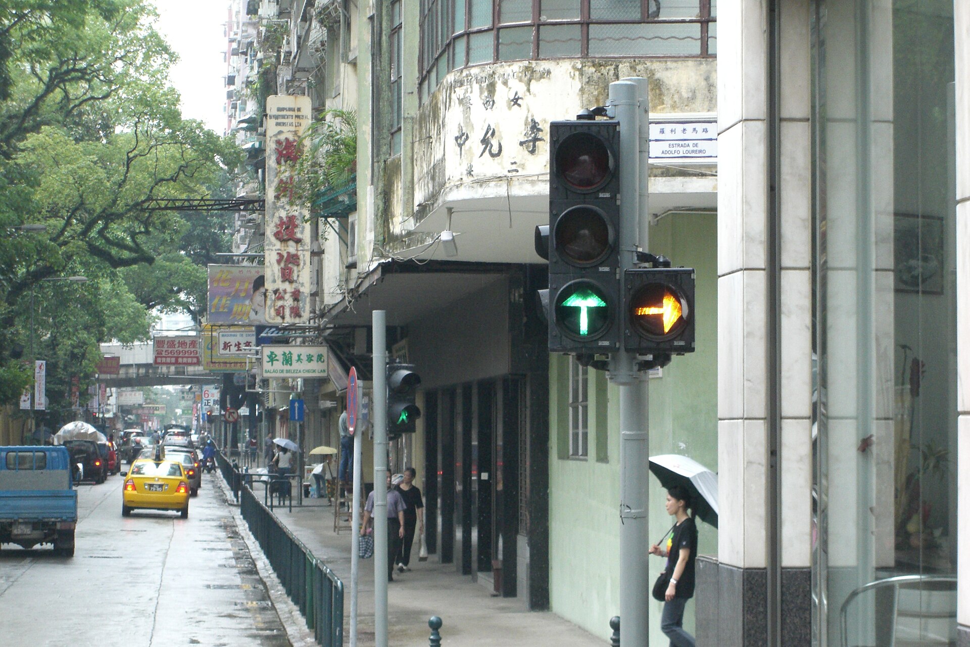 Traffic lights and a bilingual street sign on a narrow Macau road