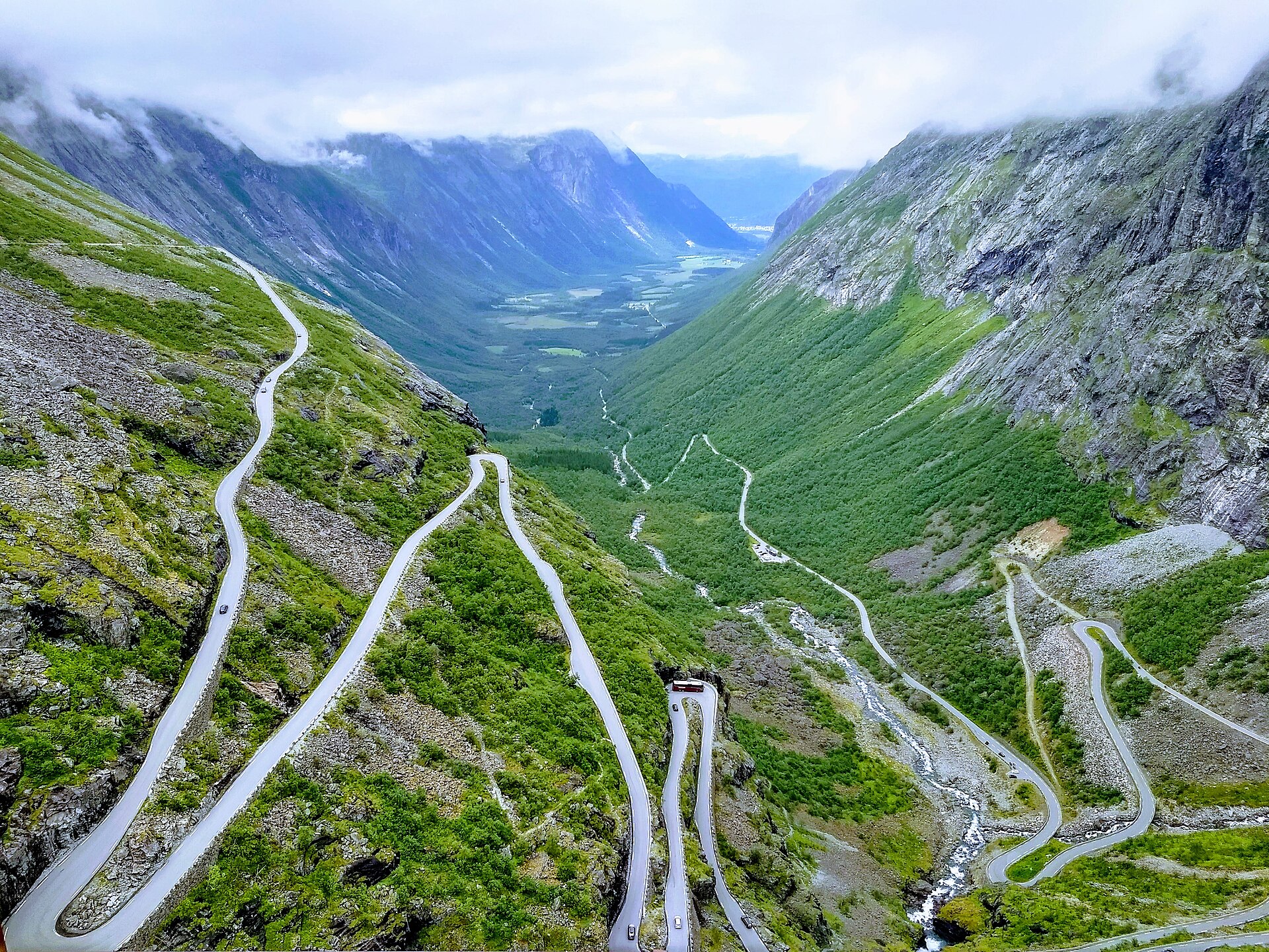 Trollstigen’s narrow hairpin road descending a green Norwegian mountain valley