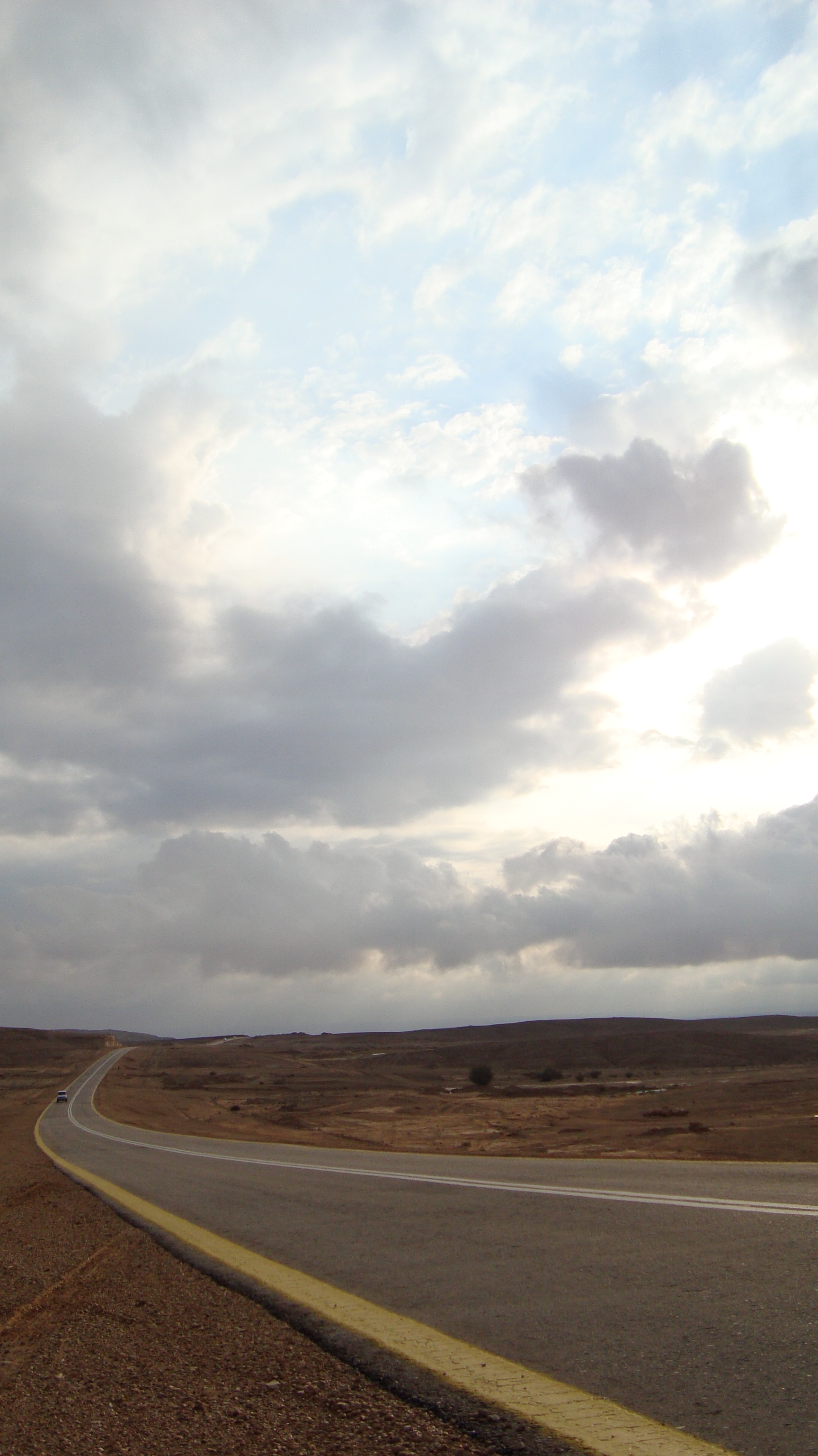 A paved road curving through the Saudi desert near Aldahina village