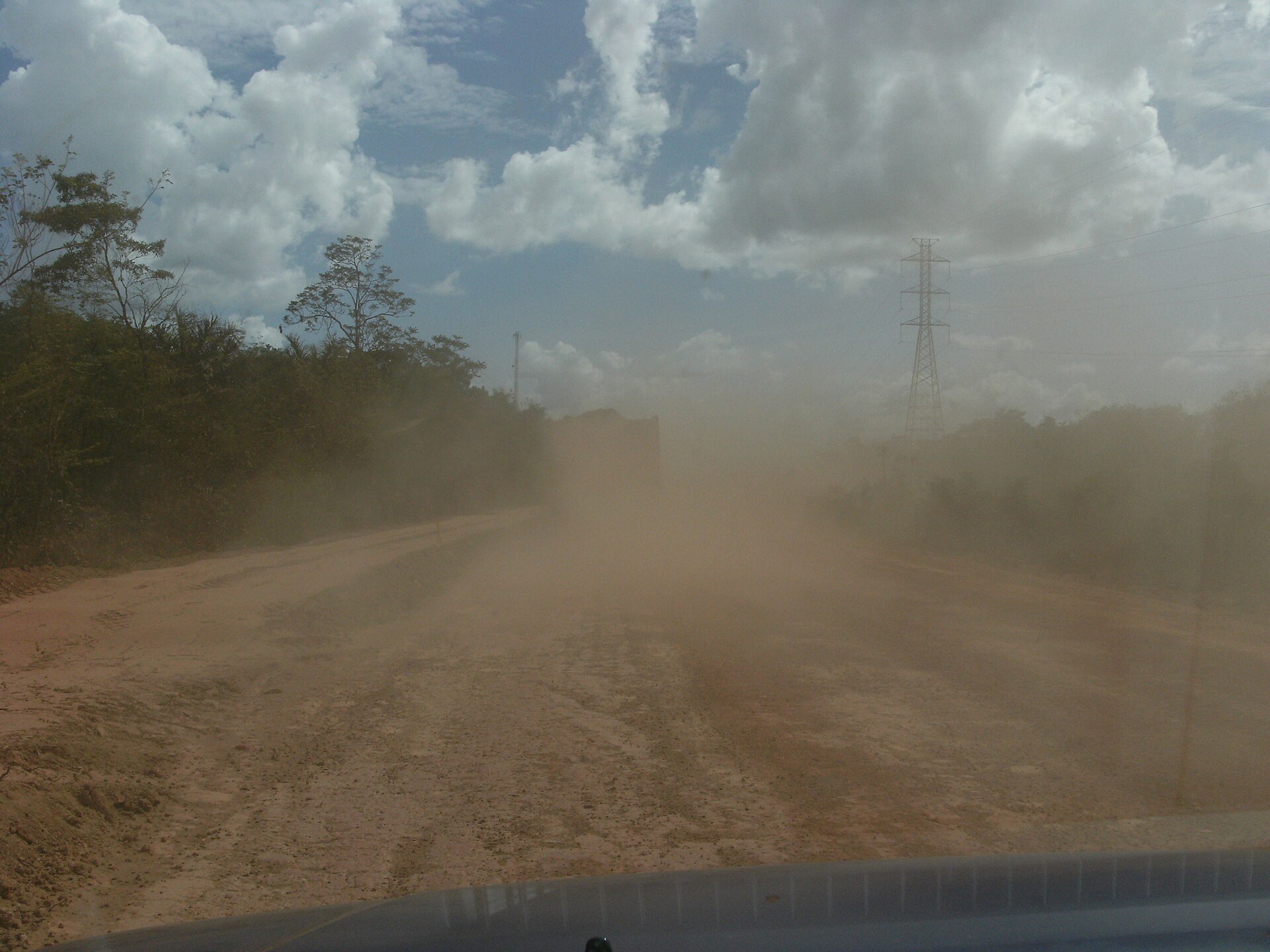 Dusty Avobaka road in Suriname leading through a forested landscape