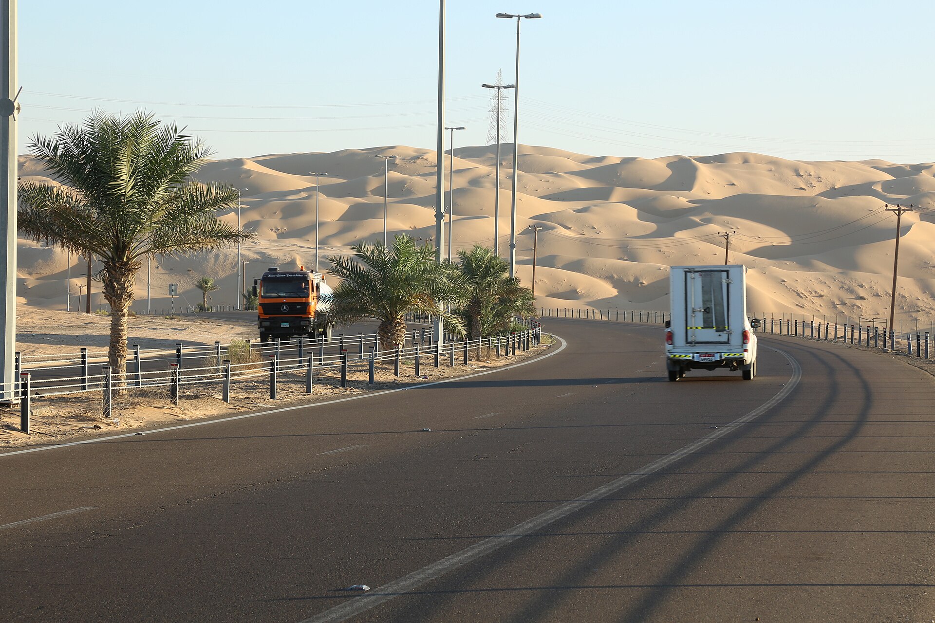 Paved road curving beside the dunes of Liwa in Abu Dhabi